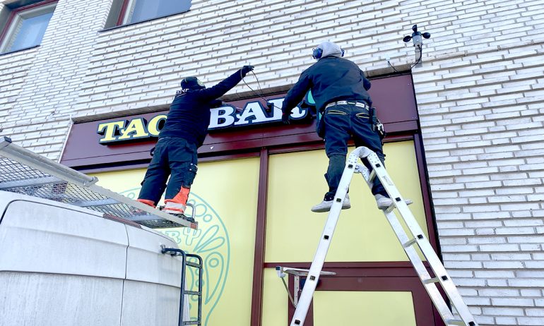 Personer som sätter upp en neonskylt