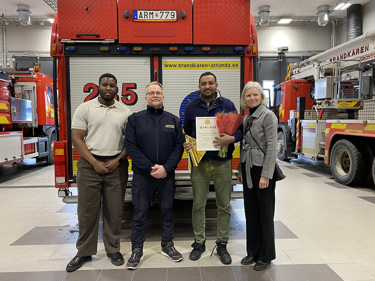 personer som står framför en brandbil